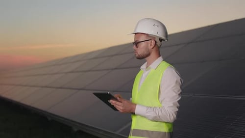 Technician Using Tablet While Standing at Solar Farm