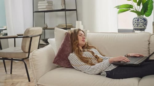 Woman Relaxes on Couch with Laptop at Home