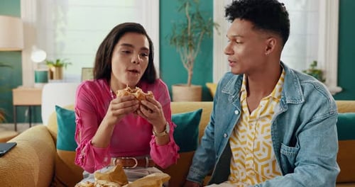 Couple Eating a Sandwich Together on Couch