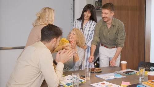 Group of business people celebrating birthday of their colleague at office.
