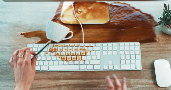 Clumsy woman spilling coffee on a computer and office table causing ...