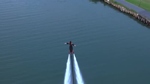 Aerial View Adventurous Female Flyboarding at Dusk