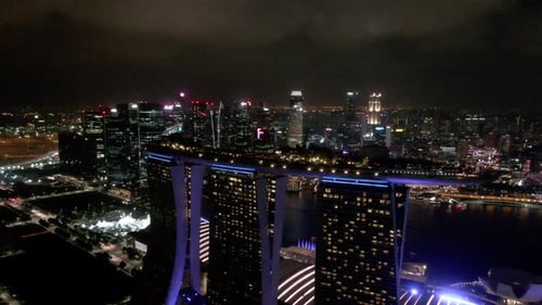 Flying out and around the Marina Bay Sands Hotel at night with the Singapore skyline in the backgrou
