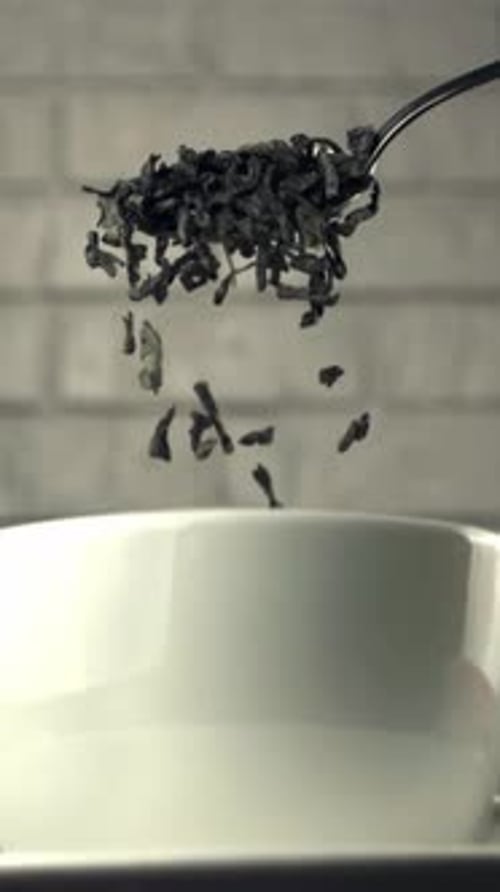 Super Slow Motion with Spoons Drop Dry Tea Leaves Into a Cup Filmed on a Highspeed Camera at 1000
