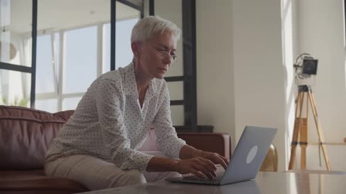 Senior Woman Working on Laptop in Office
