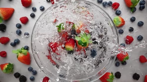 Mixed Berries Falling Into Bowl of Water
