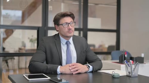 Pensive Middle Aged Businessman Sitting in Office