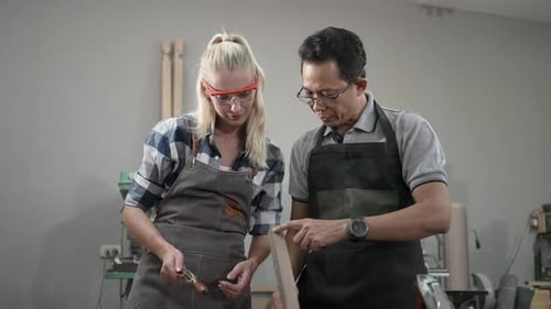 Carpenters are working together at workshop.