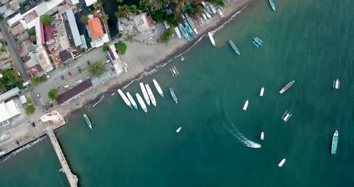 Luftaufnahme von Booten an einem Sandstrand und Pier in Indonesien