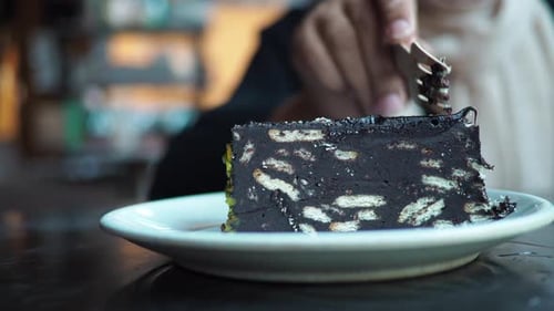 Enjoying a Slice of Delicious Chocolate Cake at a Cafe