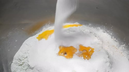 Pouring Sugar Over Flour and Egg Yolks