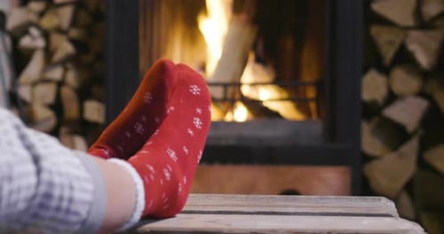 Cold fall or winter evening. People resting by the fire with blanket and tea. Closeup photo of fee