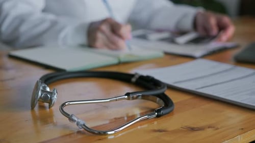 Le visage méconnaissable d'un médecin qui travaille à un bureau écrit des documents