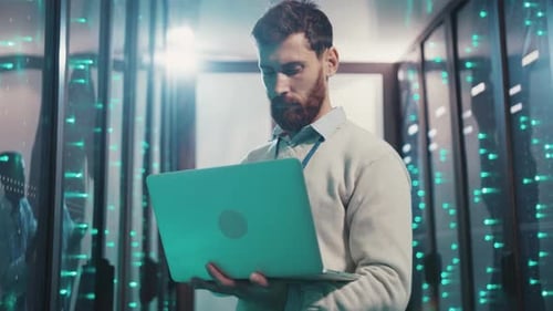 A Focused Man Navigates a Server Room Monitoring Complex Systems