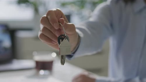 Llavero con forma de mano de agente inmobiliario con forma de casa con llaves