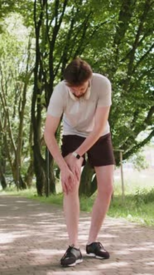 Runner Athlete Man with Muscle Leg Pain Trauma Injury While Jogging Cramp Calf Sport in City Park