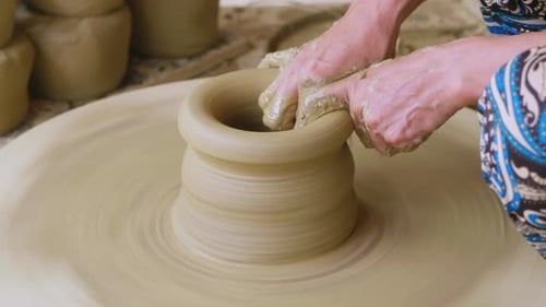 Artisan Shaping Clay Pot on Spinning Wheel