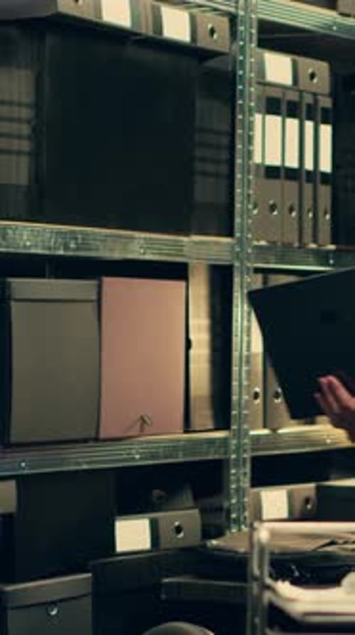 Senior Man Looking at Files in Office Archives