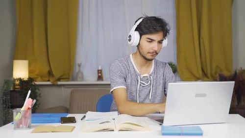 Teenage Student Using Laptop Studying At Home