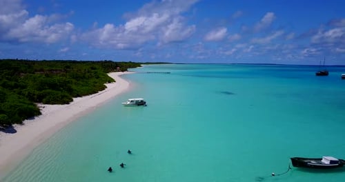 Touristen schwimmen in ruhigen tropischen Gewässern mit Jachten und Fischerbooten. Weitläufiger Strand Richtung Ho