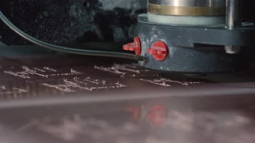 Precision milling machine cutting text into brown surface