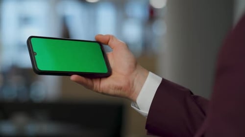 Unknown ceo swiping mockup cellphone at office green screen template device