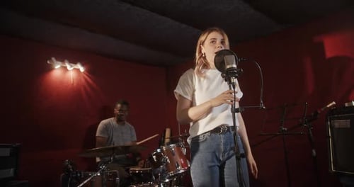 Singer Performing with Drummer in Recording Studio