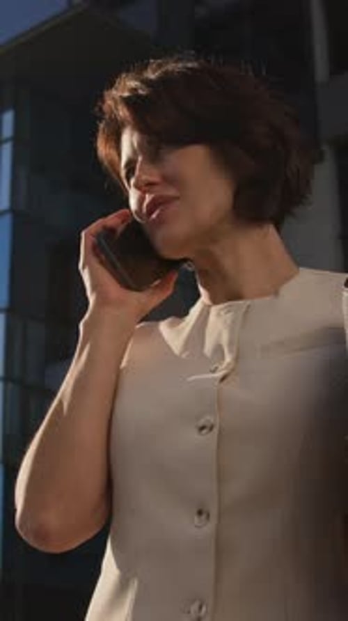 Low Angle of Brunette Entrepreneur Answering Phone Call in Business District
