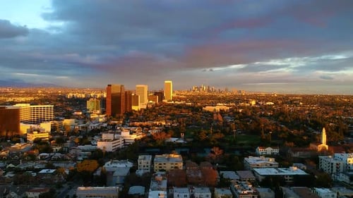 Amazing fly over the city during sunset with downtown in the distance