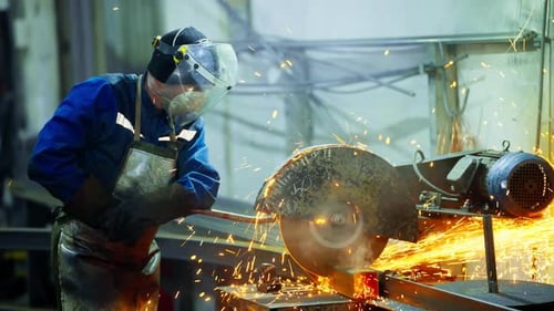 Metal Worker Using Angle Grinder on a Range Hood