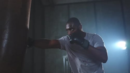 Fitness Workout in Gym Strong African Man Fighter Training Punches with Boxing Bag Healthy Boxer Man