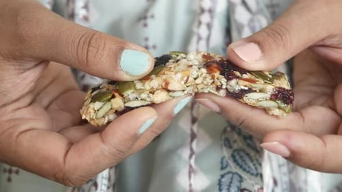 Women Hand Cracking a Protein Bar
