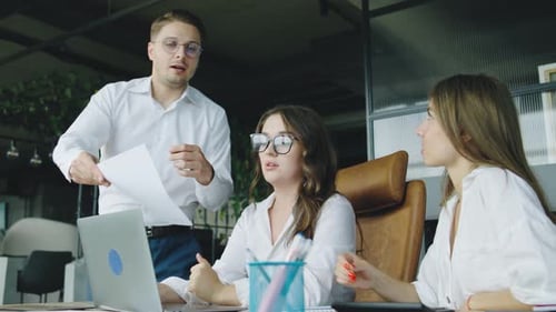 Team Collaboration in a Modern Office As Colleagues Discuss Project Details While Reviewing