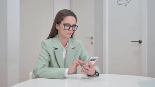 Woman Using Smartphone in Office Setting