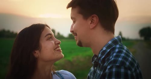 Young Beautiful Couple Hugging and Kissing Outdoors on a Countryside Road with Scenic