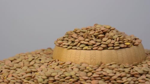 Pile of Lentils Filling Wooden Bowl