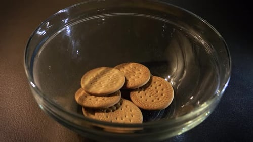 Crackers Falling Into a Clear Glass Bowl