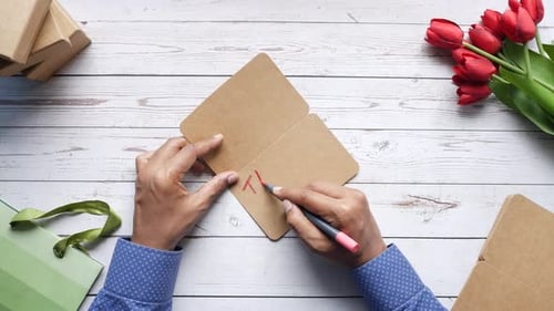 Young Men Writing Thank you Note on Table Top View