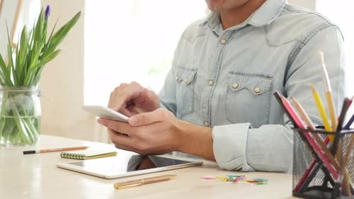 Man Using Mobile Phone at Desk in Office