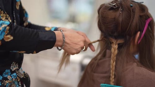 Auburn Hair Being Beautifully Braided in a Salon