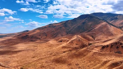 Flight over the deserted rocky landscape on sunny day.