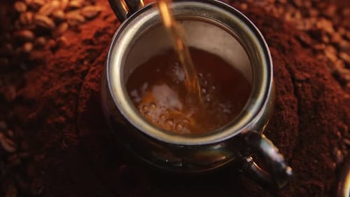 Pouring Turkish Coffee into Silver Pot Close Up