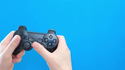 Hands play with Gamepad on Blue Background