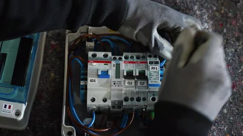 Technician Installs Electrical Equipment in a Junction Box