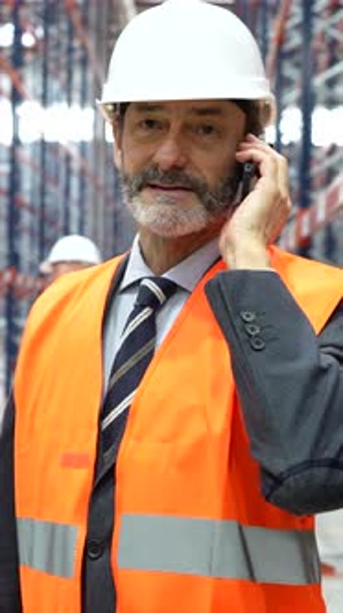 Senior supervisor talking on mobile phone in warehouse