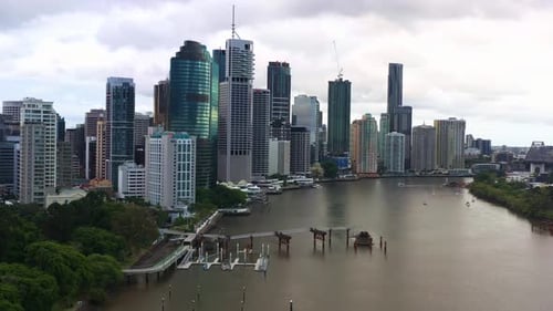 Cinematic dynamic zoom in aerial shot of riverside downtown cityscape at central business district c
