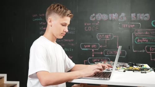 Smart teenager coding or programming system at table with equipment. Edification