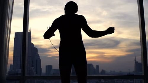 Man Dancing Against Sunset City View
