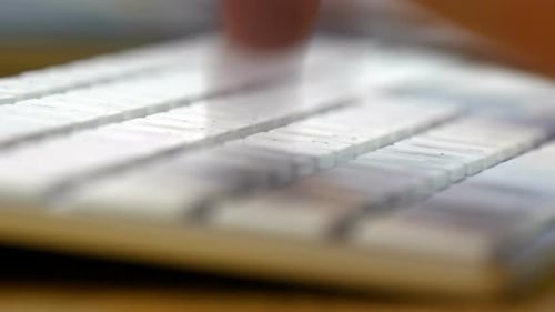 Vista aproximada das mãos de um homem digitando em um teclado de computador