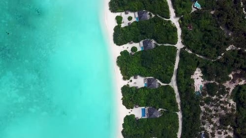 Downward angle drone shot of island resort in the Maldives. Private beach Hideaway resort.